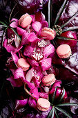 An arrangement of pink shades made from flowers, vegetables and macaroons (full frame)