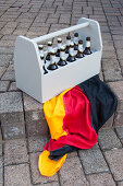 A grey beer bottle carrier with a German flag