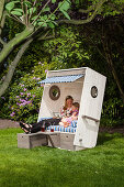 Woman and child sitting in DIY wooden beach chair