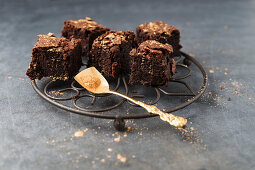 Brownies decorated with gold powder on a wire rack