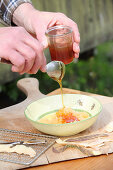 A man making cough syrup by pouring honey over grated radishes