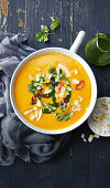 Sweet potato and carrot soup with coriander oil, chili and coconut chips