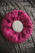 Cushion with knitted cover and knitted flower