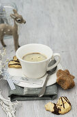 Cup of coffee with Christmas biscuits, handmade name tag and deer figurine