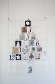Christmas cards arranged in the shape of a Christmas tree on wire memo board