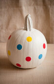 White-painted pumpkin decorated with polka-dot stickers
