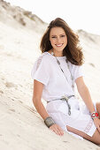 A brunette woman wearing a white summer dress