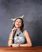 A young woman wearing a headpiece and a necklace with a printed dress