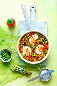 Shakshuka with green asparagus, beans and peas