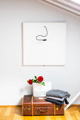 Pullovers and roses in gift bag on vintage suitcase on floor
