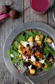Potato salad with beetroot and chanterelles on baby spinach and rocket