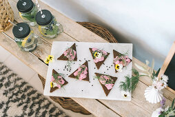 Triangular open faced sandwiches with pink fish spread