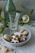 Cinnamon stars, vanilla crescent biscuits and shot glasses on a plate