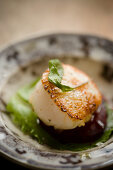 A scallop on beetroot with sage