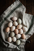 Mit Naturfarben gefärbte Eier auf Leinentuch (Aufsicht)