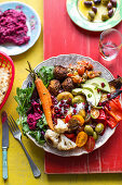 Beetroot hummus, falafel, flat bread, mezze, mutabal, olives, peppers, pommigranet, roast carrots, roast cauliflower, roast potates, salad