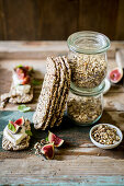 Festive dukkah in a jar as a gift served with low carb seeded crackers, figs, cream cheese and basil