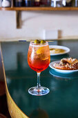 Ein Aperol Spritz im Glas mit Olivenspiesschen