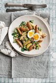 Kartoffelsalat mit dicken Bohnen, wachsweichem Ei und Kochschinken-Crumble