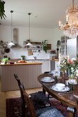 Set dining table next to open-plan kitchen in country-house style