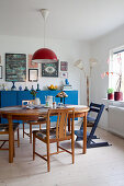 Wooden table and chairs in front of blue sideboard in dining room