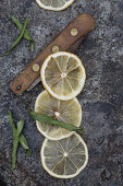 Dried bergamot slices and a vintage folding knife on a gray background