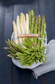 Various types of asparagus in a wire basket