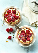 Raspberry tartlets with vanilla pudding on a marble platter
