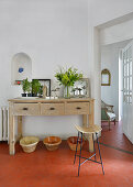 Bar stool in front of console table on hexagonal floor tiles