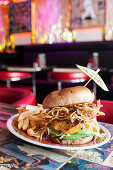 Vegan burger with avocado, soy cheese, fried onions and french fries