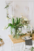 Table set for wedding with vase of tulips, dry twigs and pillar candles
