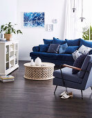Blaues Polstersofa mit Kissensammmlung, gepolsterter Armlehnstuhl, Coffeetable und Vitrinenschrank im Wohnzimmer