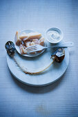 Smoked fish with sour cream on a serving platter with a fish carcass in front of it