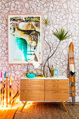 Sideboard with plants in front of wallpapered wall with stone motif