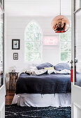 View into the bedroom with an arched window in a former church