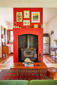 Kaminofen mit roter Wandverkleidung im Wohnzimmer