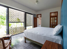 Glass wall and half-open façade in exotic bedroom