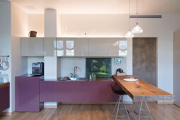 Designerküche mit rustikaler Holzplatte als Theke
