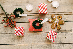Guest favours in read-and-white striped boxes, gingerbread Christmas-tree decoration and small wreath