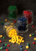 Colourful chocolate drops in glass jars
