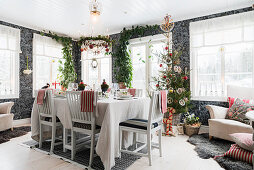 Set dining table and Christmas tree in open-plan interior