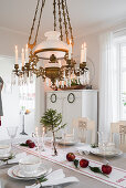 Chandelier above festively decorated dining table