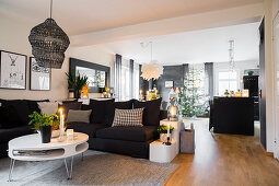 Sofa and round coffee table in open-plan interior with Christmas decorations