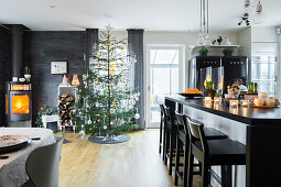 Elegant island counter, Christmas tree and fireplace in open-plan interior