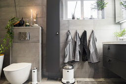 Bathroom with grey wall tiles, toilet and washstand