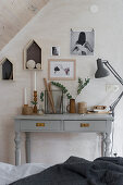 Ornaments in natural shades above grey desk in bedroom