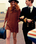 A young woman wearing an orange dress with a pilot