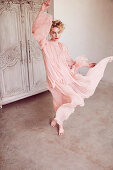 A blonde woman wearing a romantic, delicate pink dress
