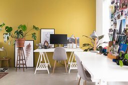 Two desks on trestles against yellow wall