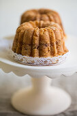Two mini coffee cakes with almonds on a cake stand